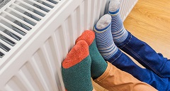 Füße mit bunten Socken wärmen sich an der Heizung