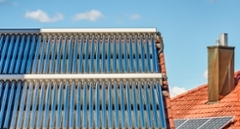 Dach mit Solarthermie-Anlage symbolisiert Heizen mit erneuerbarer Energie