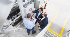 Drei Männer prüfen die Energieeffizienz in einem Unternehmen