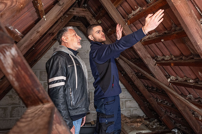 Personen prüfen die energetische Sanierung eines Daches
