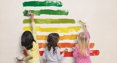 Drei Kinder malen die Streifen des neuen Energielabels zur Darstellung von Energieeffizienz an die Wand