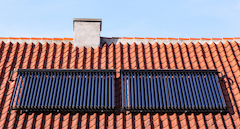 Solarthermie-Anlage auf Dach symbolisiert Heizen mit erneuerbaren Energien