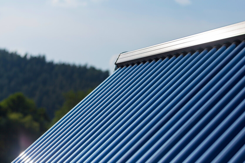 Dach mit Solarpanels symbolisiert Heizen mit erneuerbarer Energie