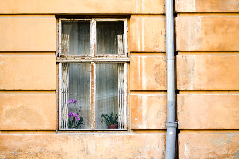 Hausfassade mit altem Holzfenster zum Thema Sanierung