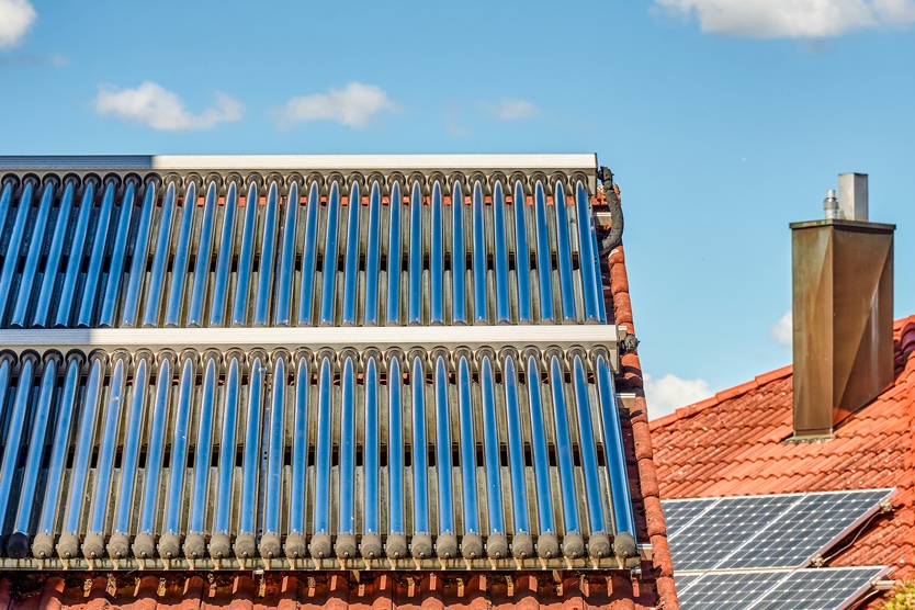 Dach mit Solarthermie-Anlage symbolisiert Heizen mit erneuerbarer Energie