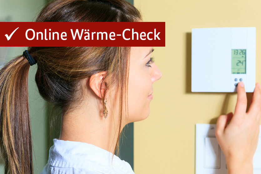 Frau regelt Heizung über ein digitales Thermostat