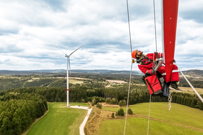 Techniker vor Windkraftanlage symbolisiert Erneuerbare Energie mit Wind
