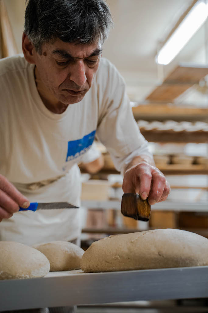 Jörg Gauger in der Bäckerei Röhrig während der den Brotteig einschneidet